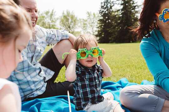Boy wearing funny glasses, sitting with his family