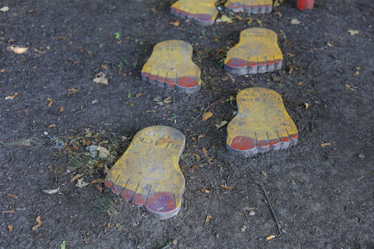 Decorative footprints on black ground. Place to walk in the garden.