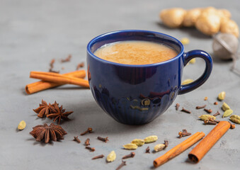 Obraz na płótnie Canvas Traditional masala chai tea. Indian hot drink made from black tea with milk and various spices on gray background with copy space