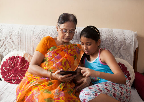 Grand mother learing to use Tablet from her Grand Children