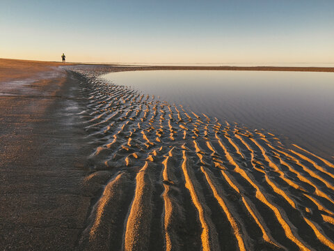 Solitary runner on the beach at sunset