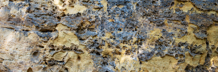 Sandstone panoramic background. Close-up of holey natural sandstone rocks