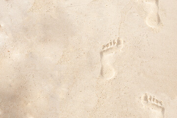 design base set of footprints on beige sand go up copy space