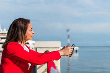 business woman in a red suit stands by the sea