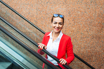 business woman goes up the escalator