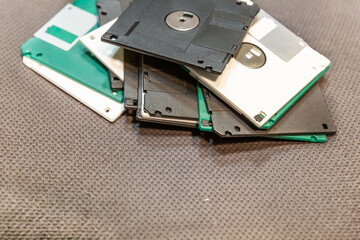 floppy disk, old data recording tool, white and black multi-colored on a dark background with copy...