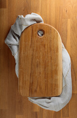 Wooden cutting board with circle hole on a oak table.