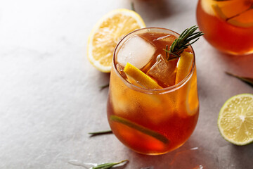 Traditional iced tea with lemon, lime and ice garnished with rosemary twigs.