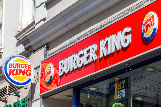 London, UK, April 1, 2012 : Burger King yellow and red logo advertising sign outside a beefburger fast food retail business restaurant in the city centre stock photo image
