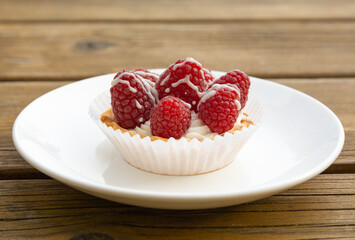 small rasberries cake on white dish.