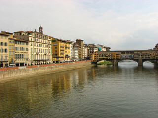 Florence, Italy - October 1 2006 - Ponte Vecchio, a medieval stone covered bridge over the Arno River. It was first built in 996 and is known for shops lining it. Image has copy space.