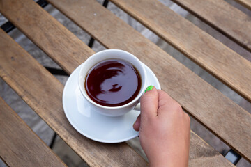 top view hand holding tea cup on wooden table
