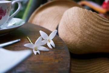 Tiny White flowers put on a brown wooden table with blurry background 