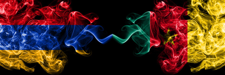 Armenia vs Cameroon, Cameroonian smoky mystic flags placed side by side. Thick colored silky abstract smoke flags