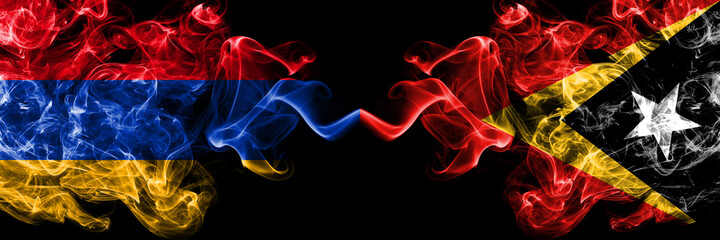 Armenia vs East Timor smoky mystic flags placed side by side. Thick colored silky abstract smoke...