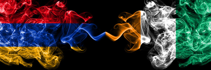 Armenia vs Ivory Coast smoky mystic flags placed side by side. Thick colored silky abstract smoke flags