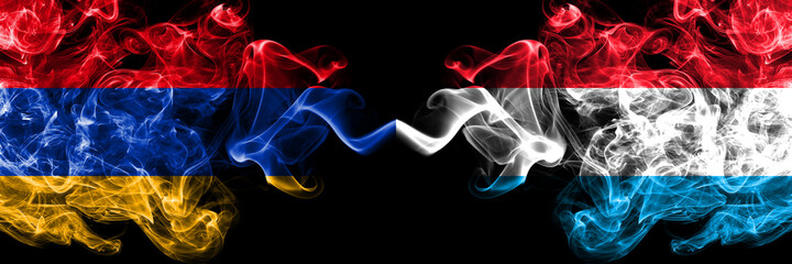 Armenia vs Luxembourg smoky mystic flags placed side by side. Thick colored silky abstract smoke flags