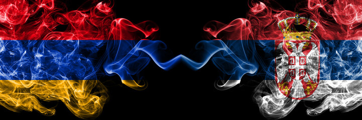 Armenia vs Serbia, Serbian smoky mystic flags placed side by side. Thick colored silky abstract smoke flags