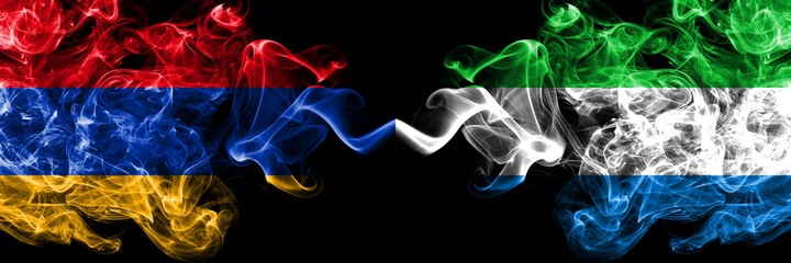 Obraz premium Armenia vs Sierra Leone smoky mystic flags placed side by side. Thick colored silky abstract smoke flags