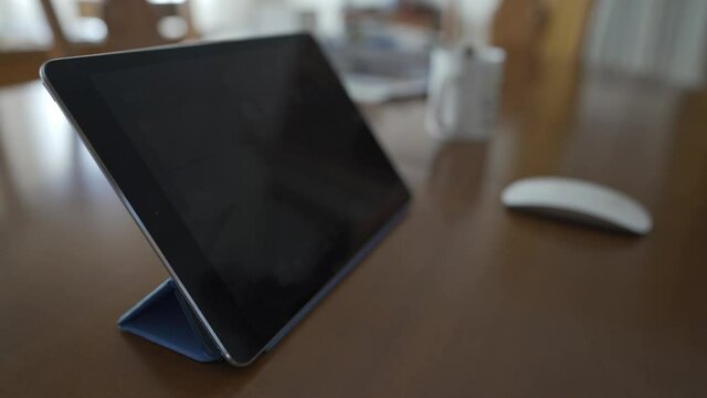 Tablet y rat&oacute;n con taza de cafe de fondo