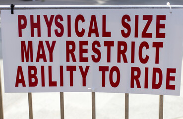 Sign posting restrictions for obese riders at an amusement park on thrill rides and roller...