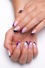 Colored French manicure on long sharp nails close-up on a white background. Gel design white, blue,...