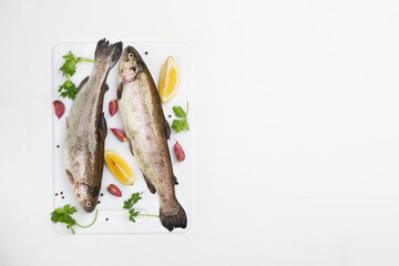 Two raw trouts with spices and lemon, top view