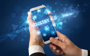Female hand holding smartphone with INDUSTRY 4.0 inscription, modern technology concept