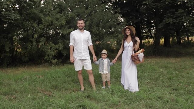 Happy caucasisn family with one beautiful child before a picnic in the park