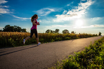 Fototapeta premium Teenage girl running against blue sky 