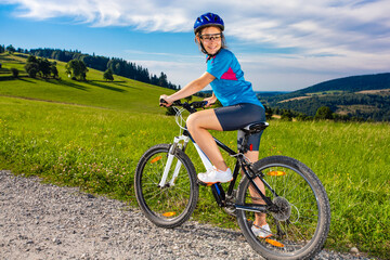 Young woman riding  bicycle on country road

