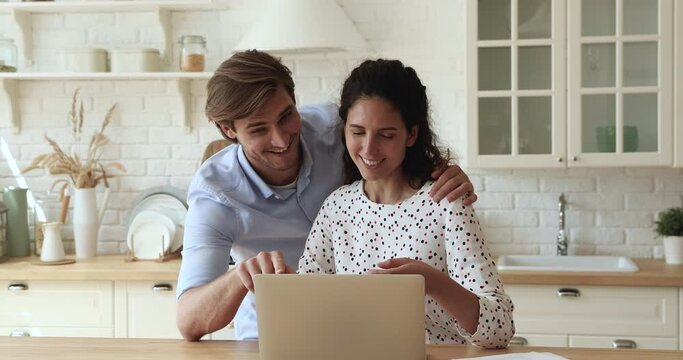 Astonished couple read message on laptop celebrate success. Spouses check email receive notice about lottery win feels happy, sport game fan victory moment, loan approved great opportunity for family