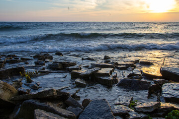 Sunset Beach. Waves crash on the coast of Lake Michigan with a beautiful sunset horizon.