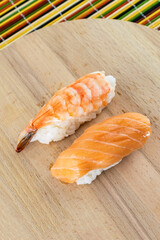 sushi set fresh shrimp and salmon on rice lies on a wooden background