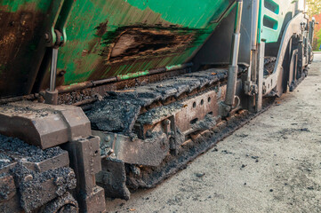 a dirty caterpillar of asphalt paving machine