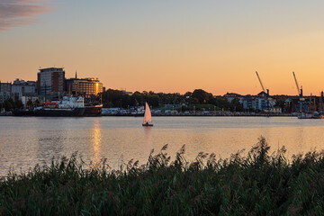 Blick über die Warnow auf die Hansestadt Rostock mit Segelboot