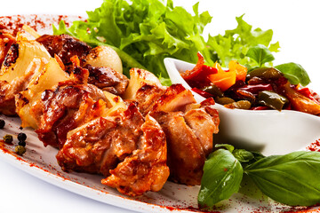 Grilled shashlik with vegetables on white background
