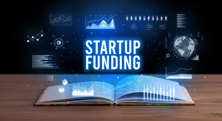 STARTUP FUNDING inscription coming out from an open book, creative business concept