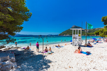 Platja de Formentor, Mallorca, Spain - July 20, 2020: People enjoying popular beach in summer, Mallorca, Spain.