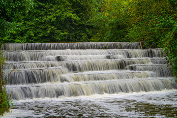 White Water flowing over weir low-level view at long exposure to give blurred motion effects