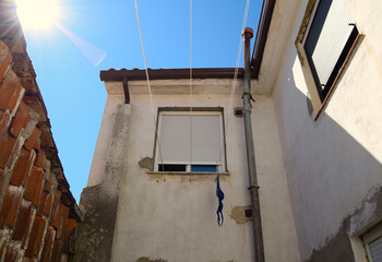 Old ruined windows in a courtyard with sunlight and blue sky