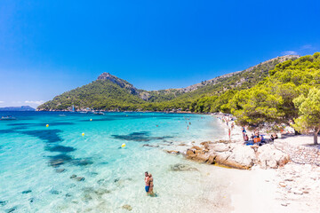 Platja de Formentor, Mallorca, Spain - July 20, 2020: People enjoying popular beach in summer, Mallorca, Spain.