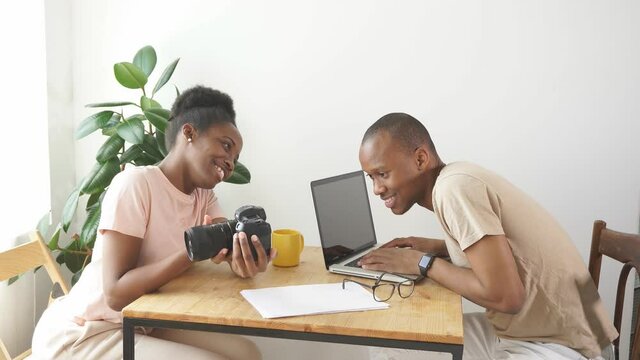 cheerful woman shows photo on camera to her husband, they have conversation and discuss. at home