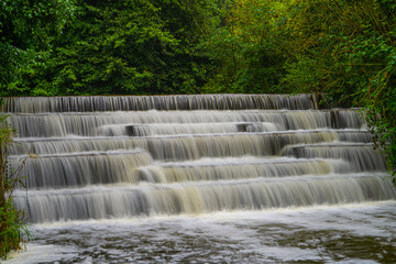 White Water flowing over weir low-level view at long exposure to give blurred motion effects