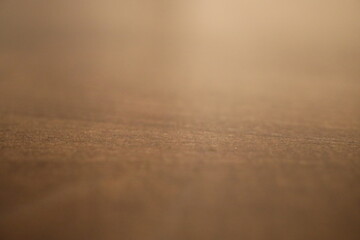 Eine dunkelbraune Holztischoberfläche aus der Nähe fotografiert sodass man die Muster und Verläufe gut erkennt.