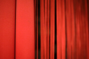 ein roter Vorhang mit Streifen aus der unmittelbaren Nähe fotografiert. Man sieht die Nähte und den Strickmuster.