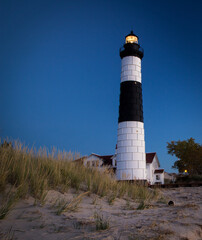 Illuminated Great Lakes Lighthouse In Vertical Orientation. Historical Big Sable Lighthouse on the coast of Lake Michigan in Ludington State Park.