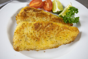 filet de poisson meunière cuit dans une assiette