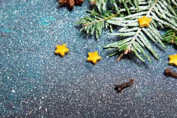 Beautiful Christmas background with decorations. Fir twigs and small yellow stars on dark background. Copy space for your text