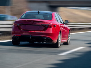Fototapeta na wymiar Red sports car on German highway (Autobahn), selective focus blurry background